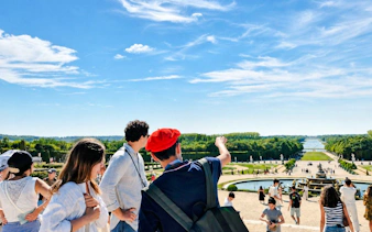 Visitors exploring Versailles Palace gardens on a guided tour, France.