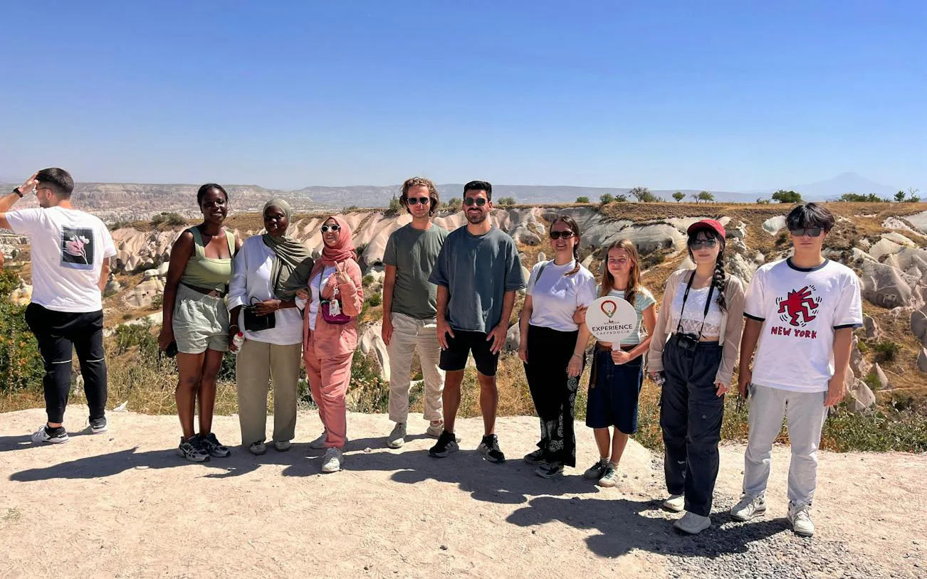 Group of tourists on a Private Mix Tour in Cappadocia with rock formations in the background.