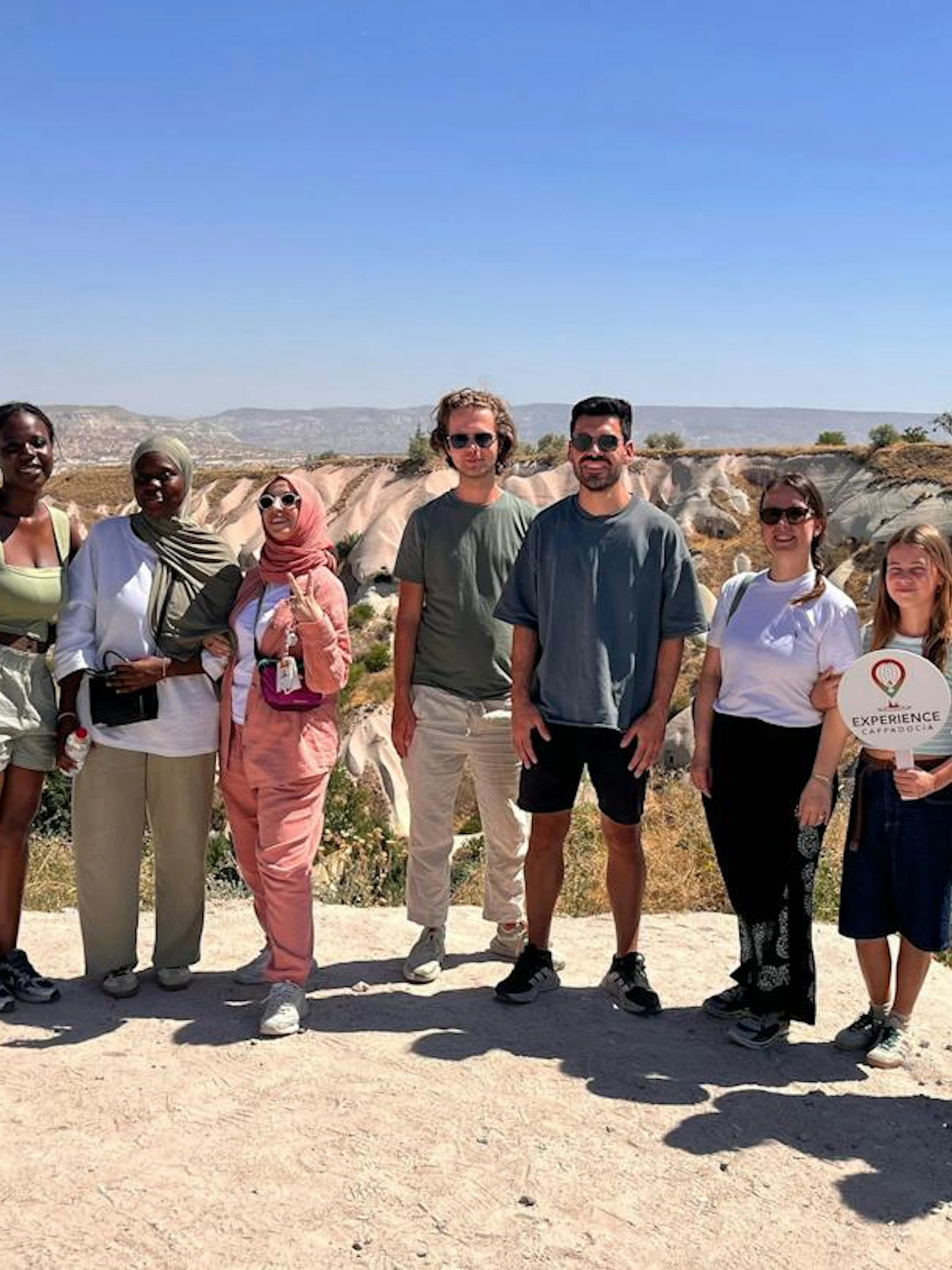 Group of tourists on a Private Mix Tour in Cappadocia with rock formations in the background.