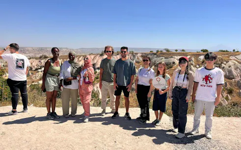 Group of tourists on a Private Mix Tour in Cappadocia with rock formations in the background.