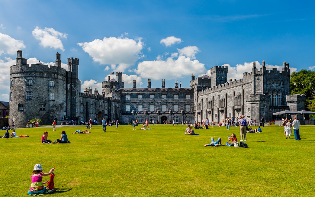 Visitors enjoying the gardens in front of Kilkenny Castle, Ireland.