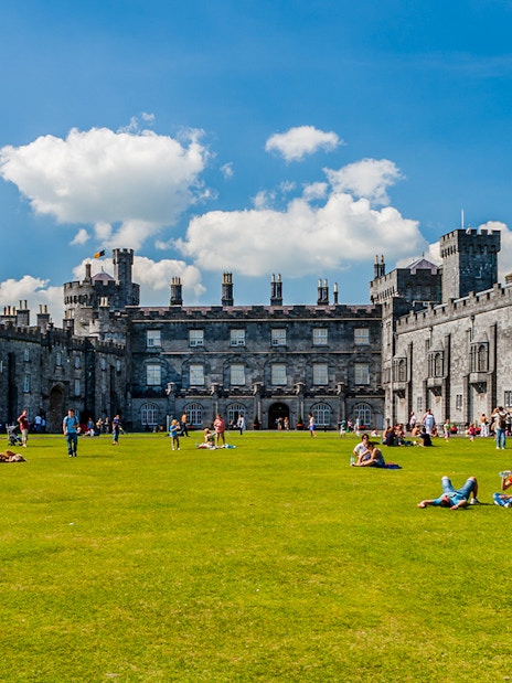 Visitors enjoying the gardens in front of Kilkenny Castle, Ireland.