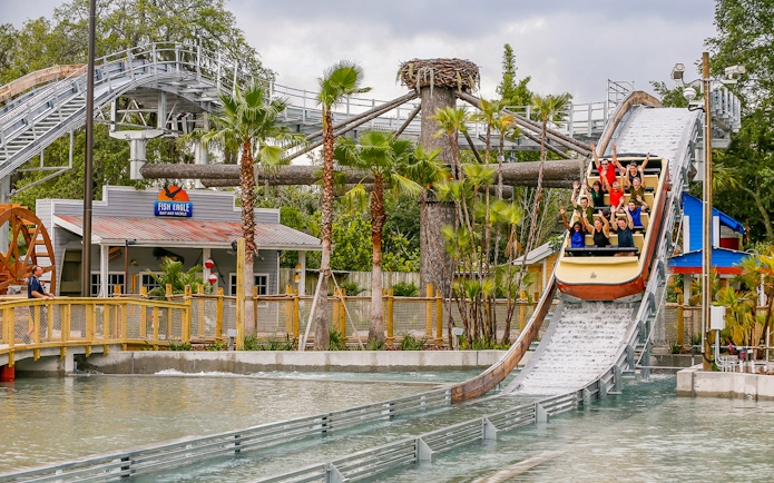 People enjoying a log flume ride at an Orlando theme park, part of the Orlando Explorer Pass.