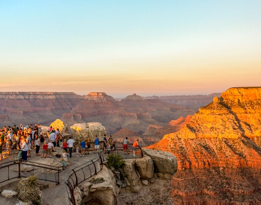 Visitors gather at Mather Point to view the sunset over the Grand Canyon, USA.