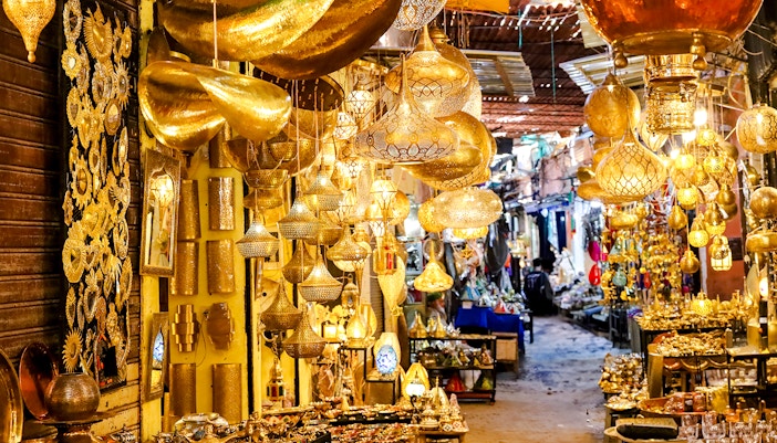 Lamps and metal crafts displayed in a vibrant souk in Marrakech, Morocco.