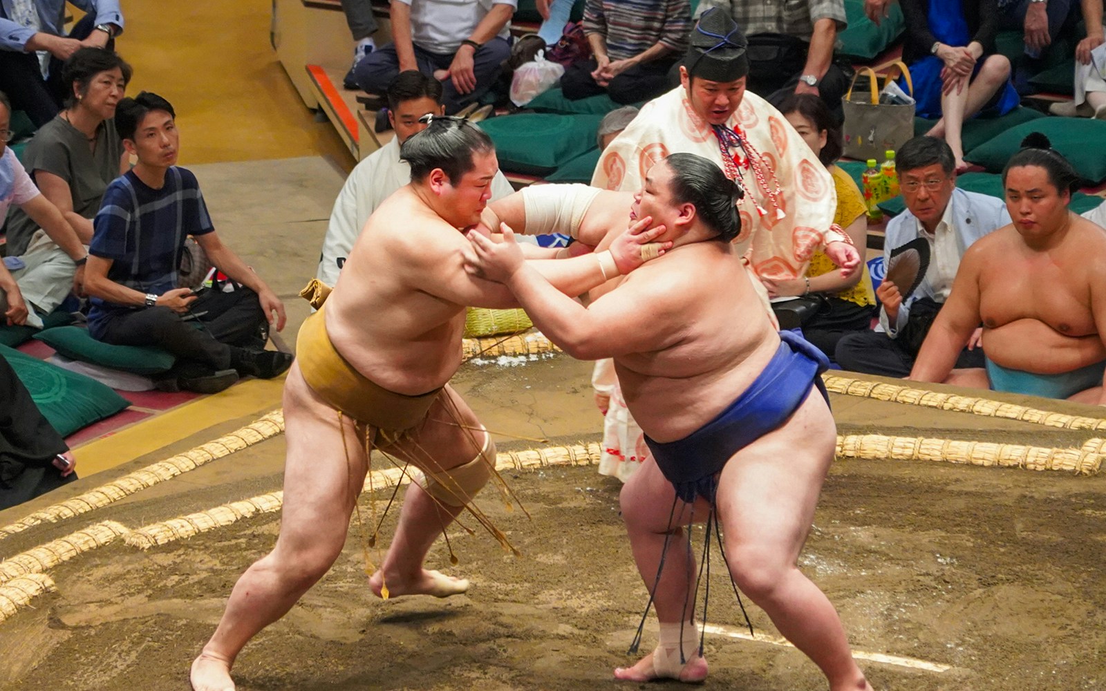 Sumo wrestlers competing in Tokyo's Ryogoku arena during a tournament.