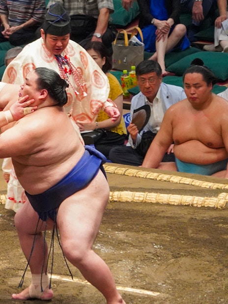 Sumo wrestlers competing in Tokyo's Ryogoku arena during a tournament.