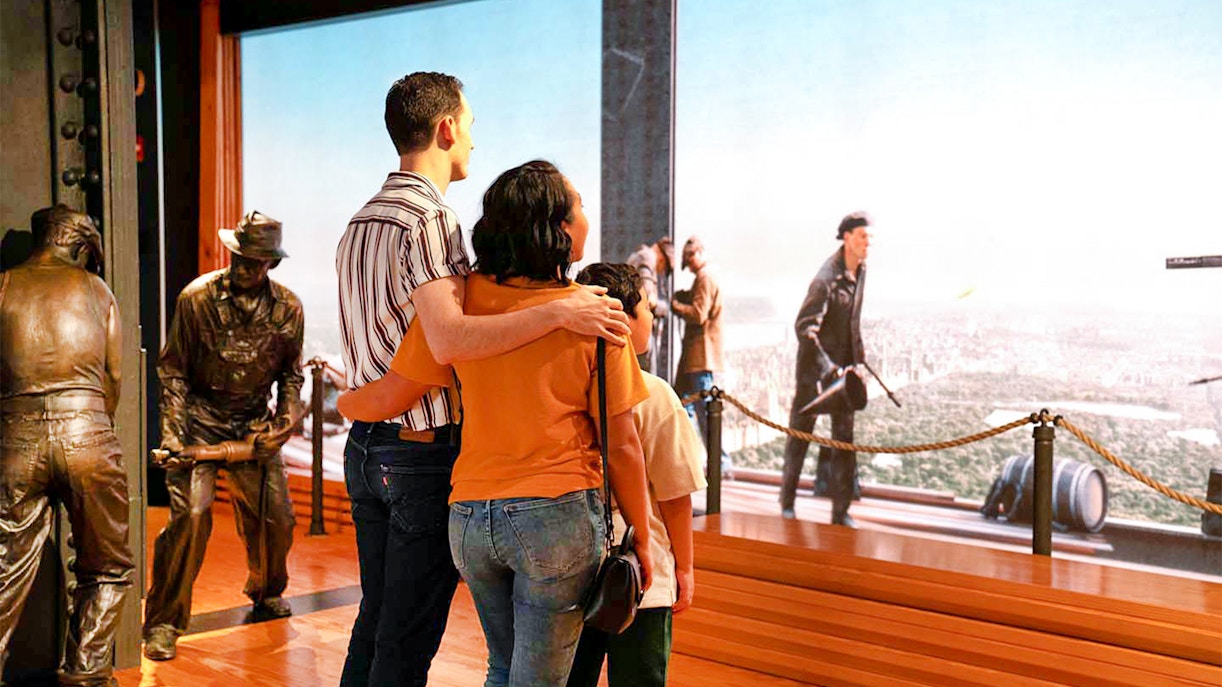 Couple viewing NYC skyline from Empire State Building exhibit.