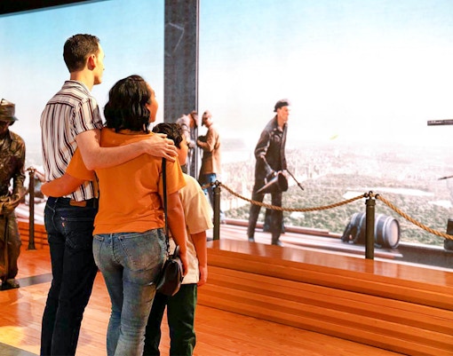 Couple viewing NYC skyline from Empire State Building exhibit.