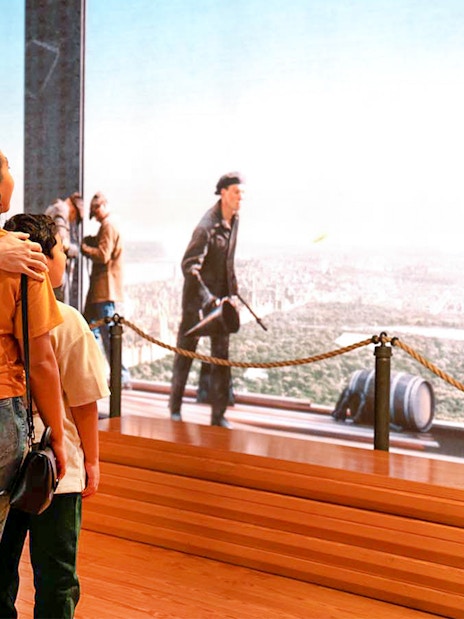 Couple viewing NYC skyline from Empire State Building exhibit.