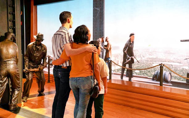 Couple viewing NYC skyline from Empire State Building exhibit.