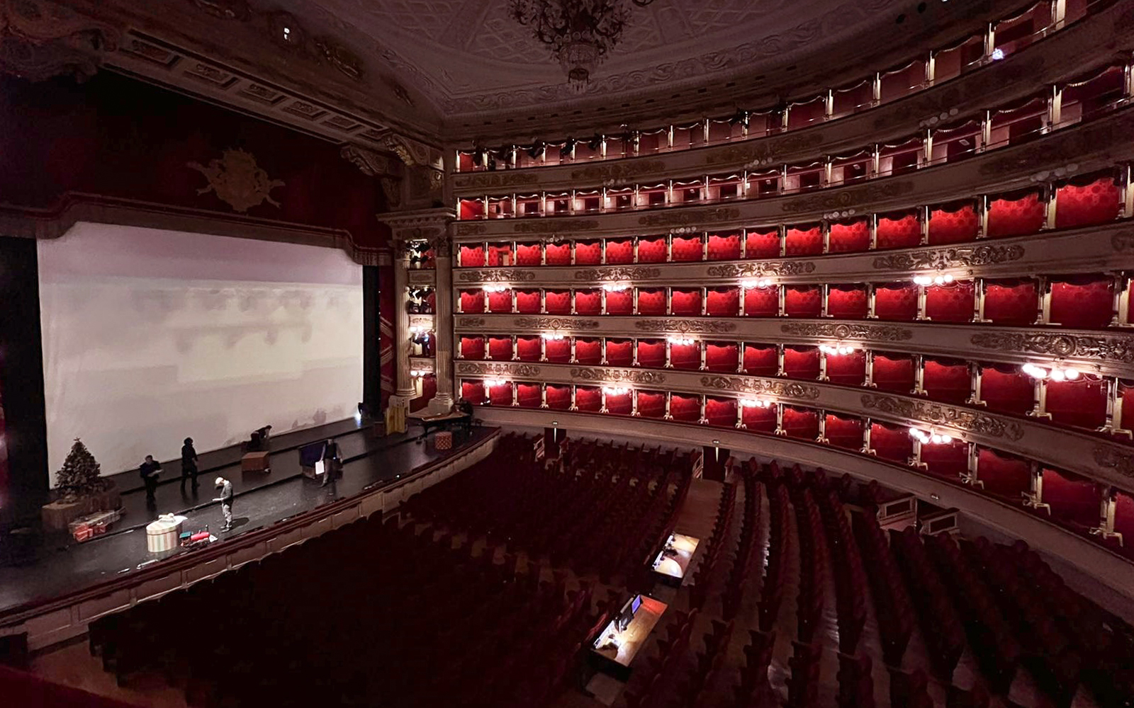 Interior of La Scala Theatre in Milan with red velvet seating and stage setup.