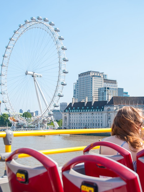 Open-top bus tour with children viewing the London Eye and River Thames.
