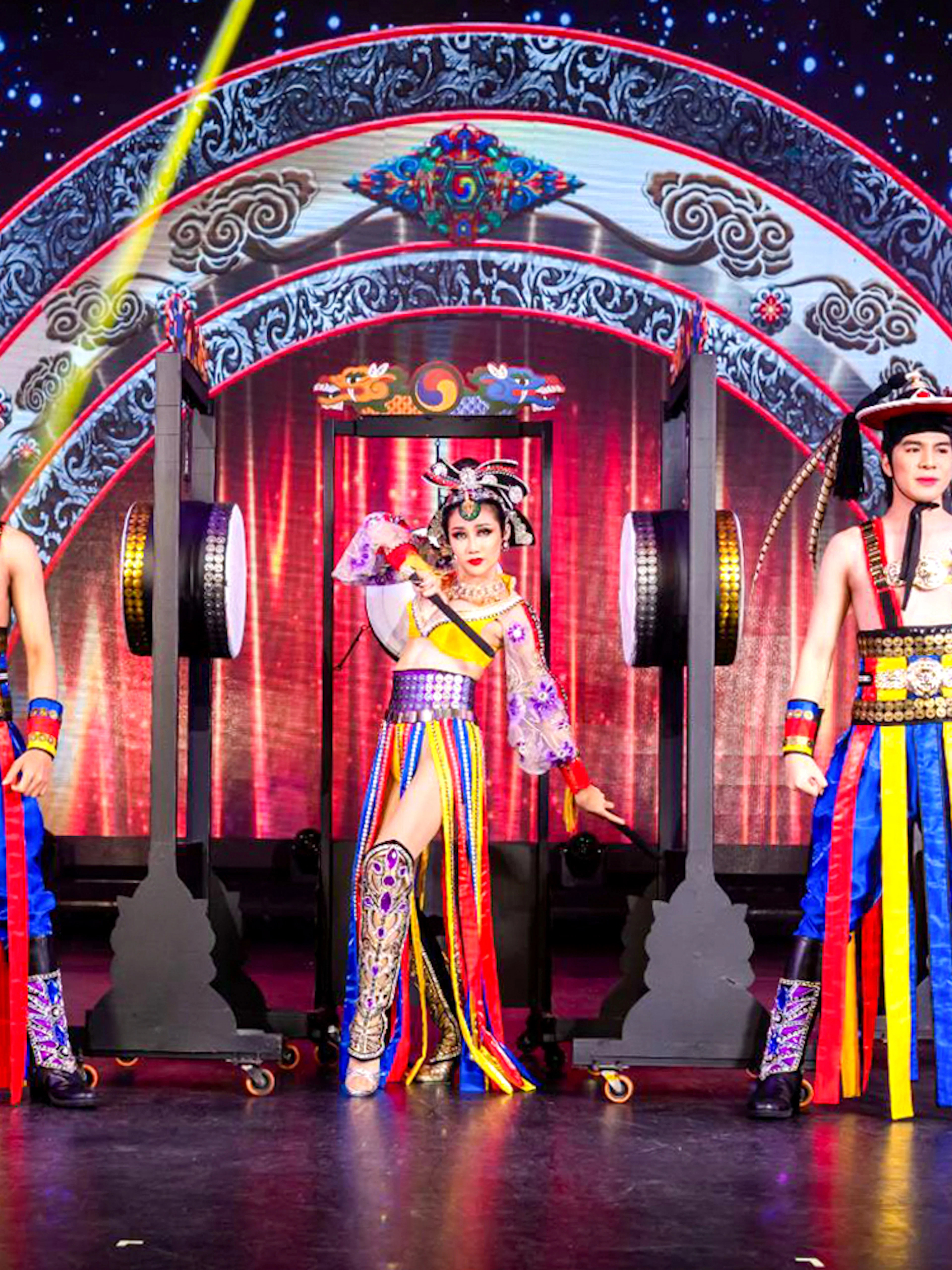 Performers in colorful costumes on stage at Simon Cabaret Show, Phuket.