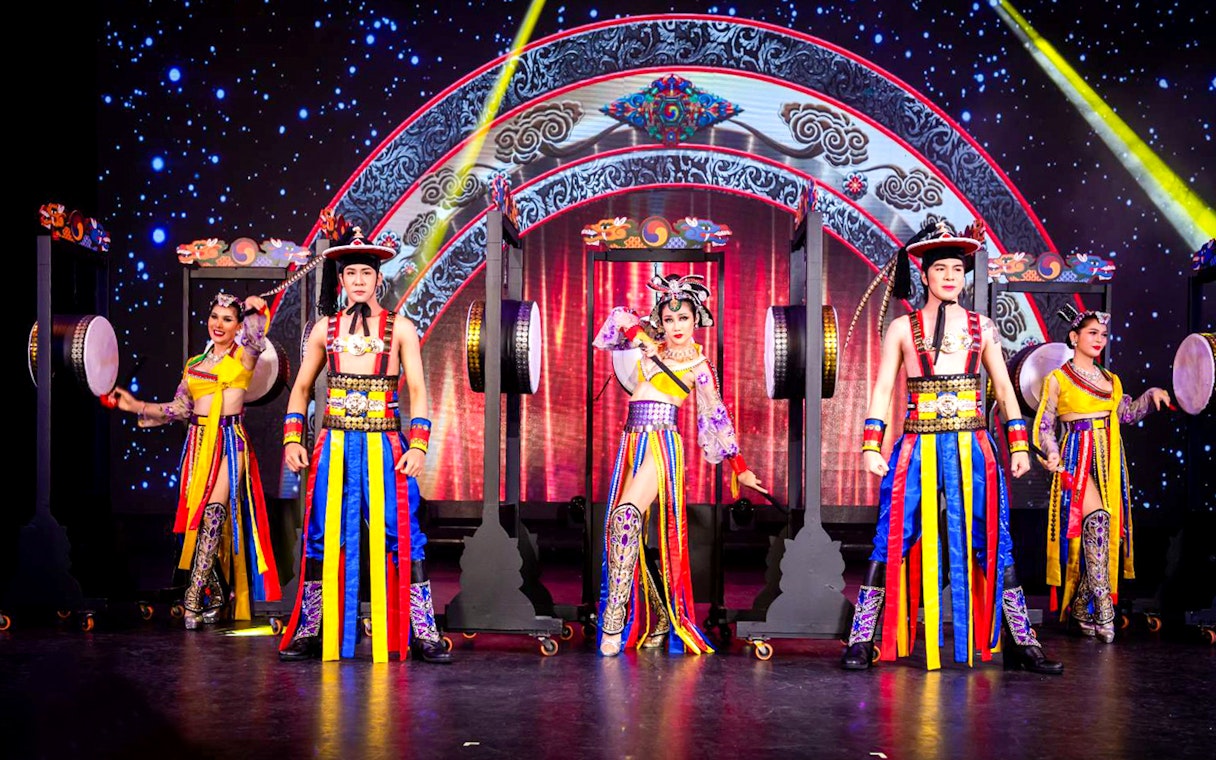 Performers in colorful costumes on stage at Simon Cabaret Show, Phuket.
