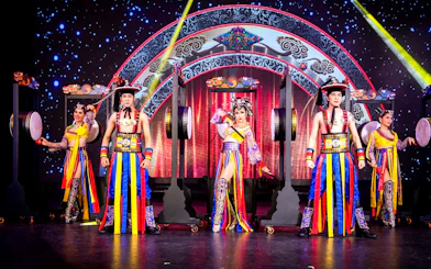 Performers in colorful costumes on stage at Simon Cabaret Show, Phuket.
