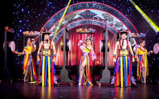 Performers in colorful costumes on stage at Simon Cabaret Show, Phuket.