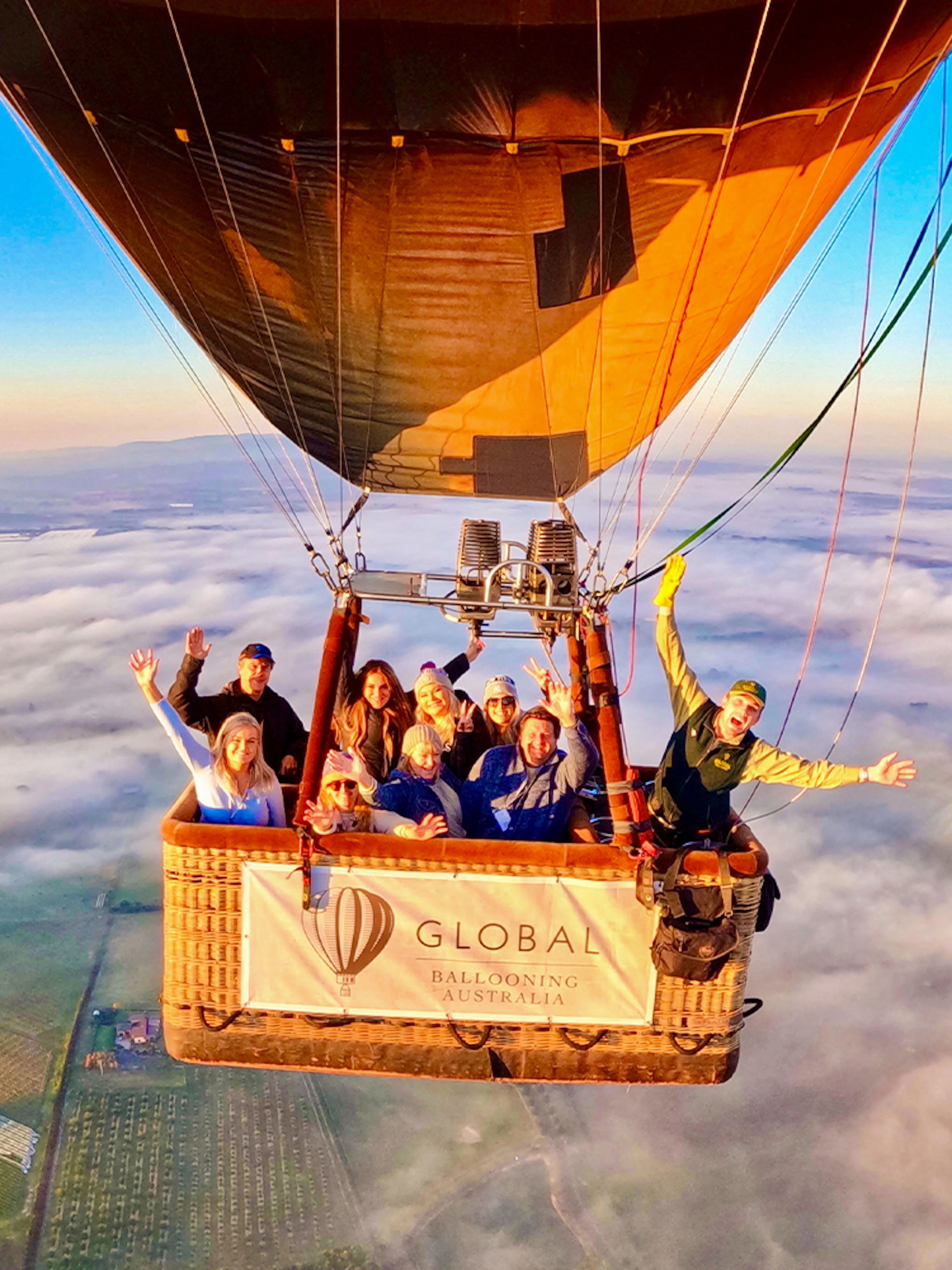 Hot air balloon with passengers over Yarra Valley at sunrise, Australia.