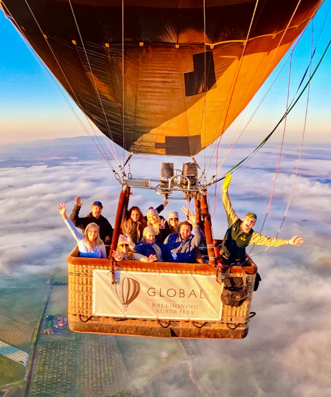 Hot air balloon with passengers over Yarra Valley at sunrise, Australia.