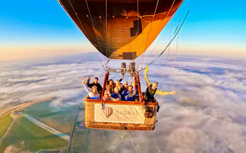 Hot air balloon with passengers over Yarra Valley at sunrise, Australia.