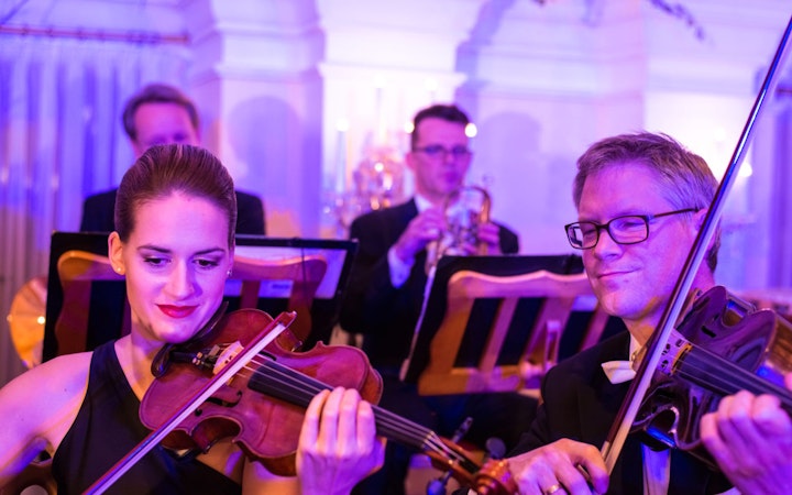 Musicians playing violins at Mozart and Strauss concert in Kursalon Vienna.