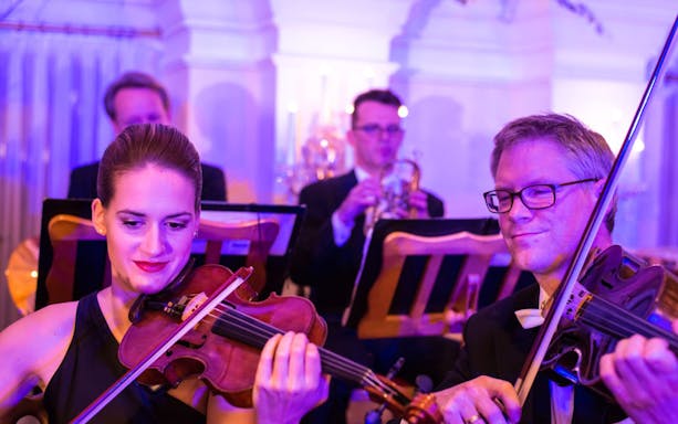 Musicians playing violins at Mozart and Strauss concert in Kursalon Vienna.