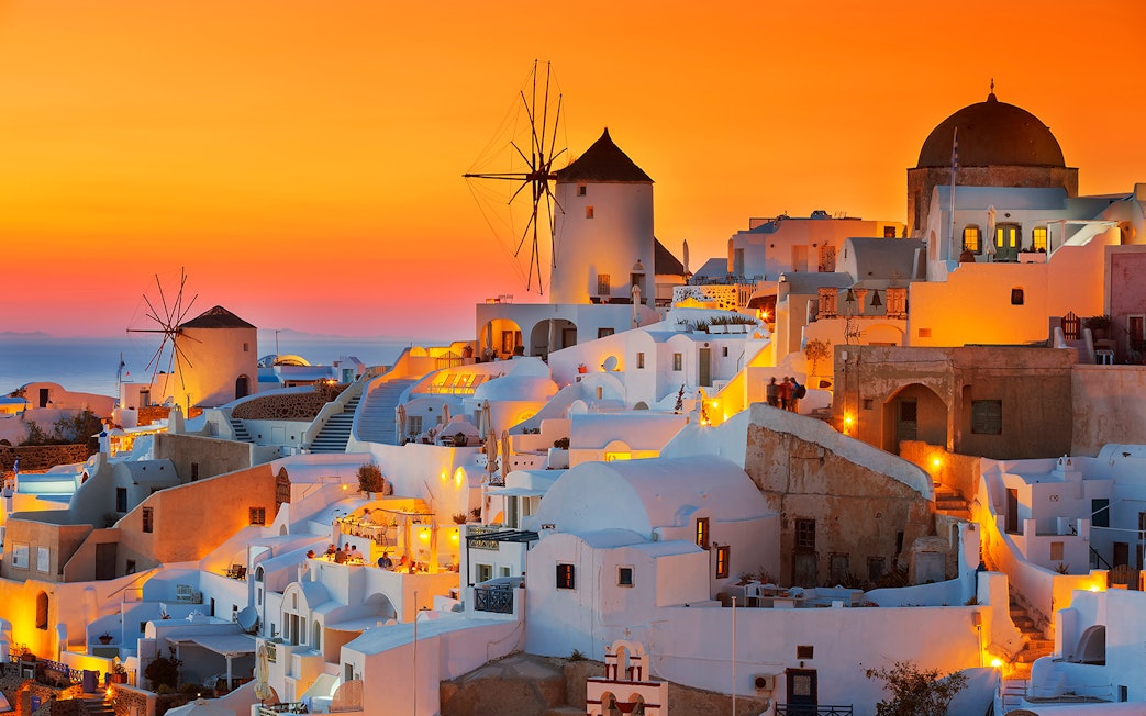 Oia village with windmills at sunset, Santorini, Greece.