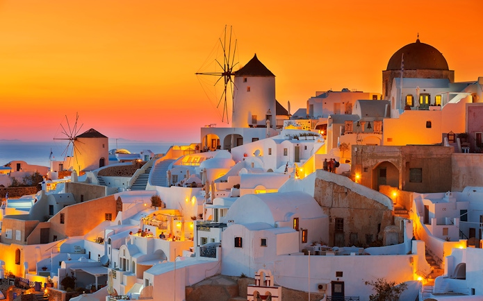 Oia village with windmills at sunset, Santorini, Greece.