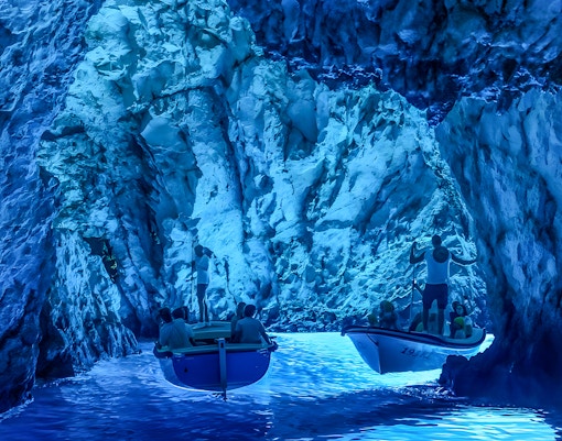 Tourists in small boats explore the Blue Cave near Split.