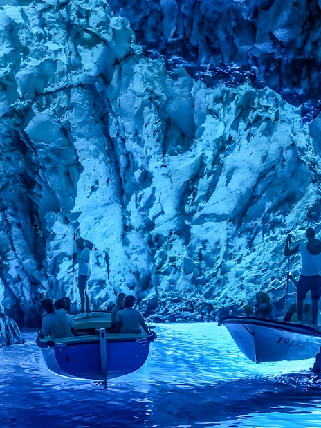 Tourists in small boats explore the Blue Cave near Split.