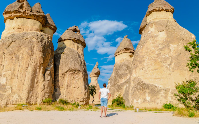 Person standing among fairy chimneys in Pasabag Monks Valley, Cappadocia.