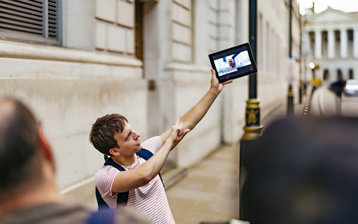 Guide showing Harry Potter film location on tablet during walking tour.
