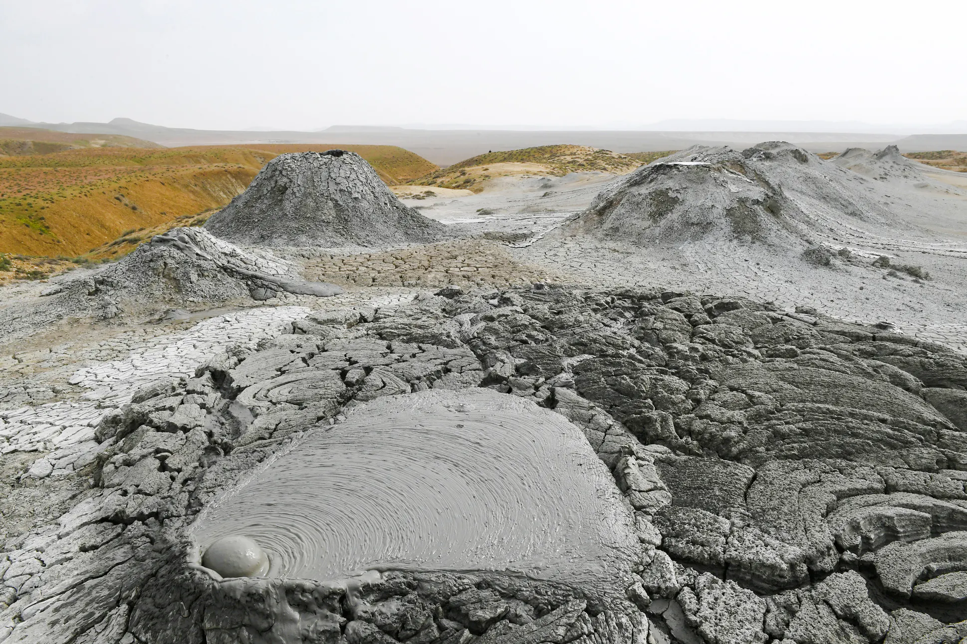 Mud volcanoes in Gobustan, Azerbaijan, with cracked earth and bubbling mud pools.