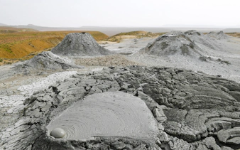 Mud volcanoes in Gobustan, Azerbaijan, with cracked earth and bubbling mud pools.