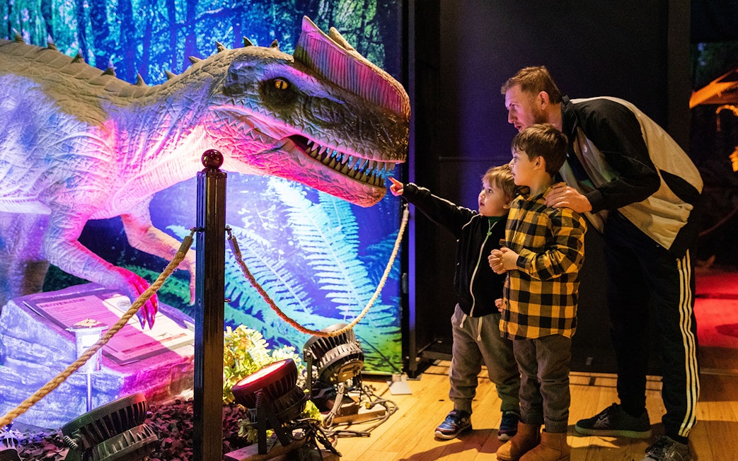 Family exploring dinosaur exhibit at Las Vegas attraction.