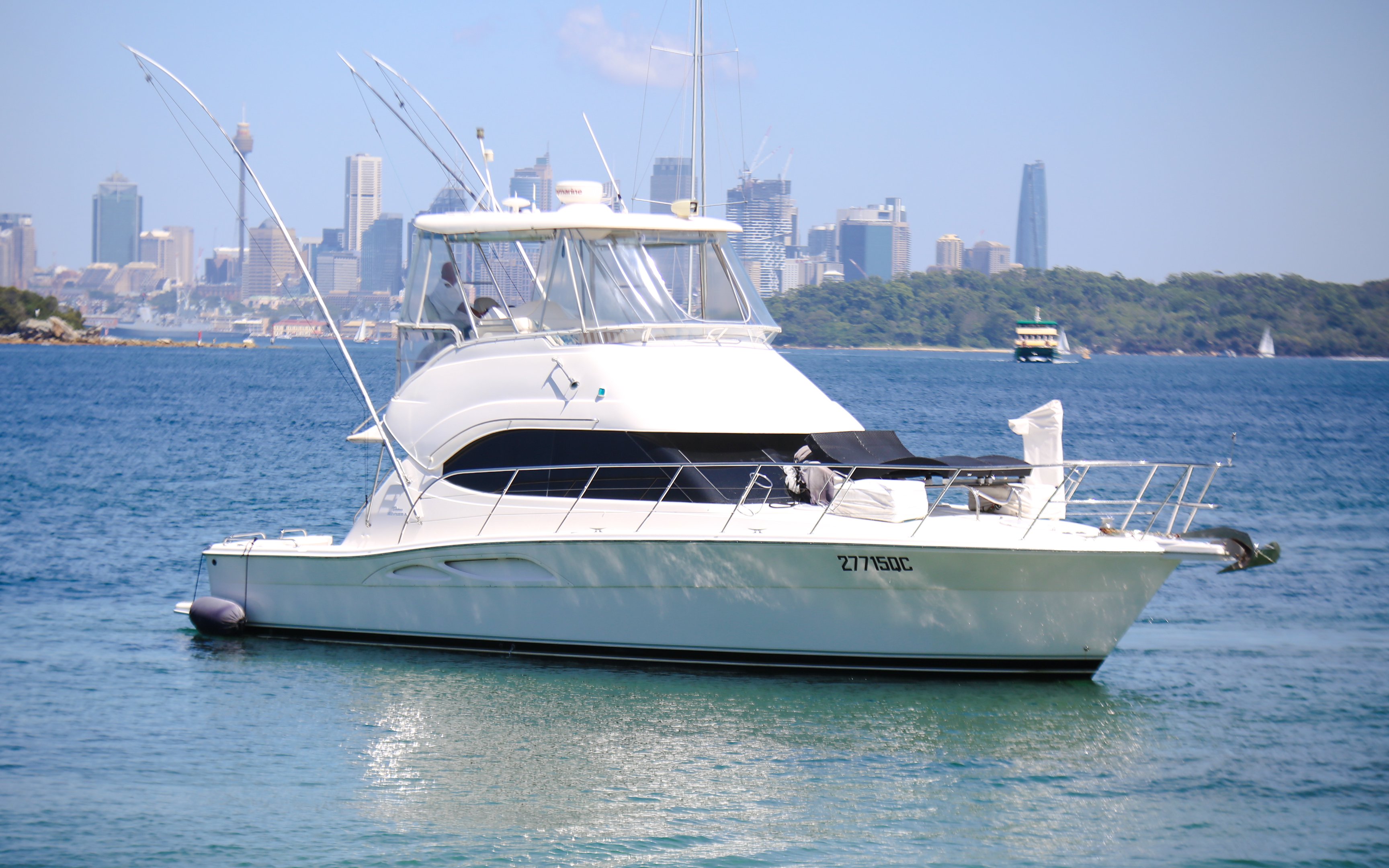 Luxury yacht on Sydney Harbour with city skyline in the background.