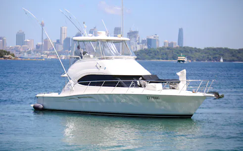 Luxury yacht on Sydney Harbour with city skyline in the background.