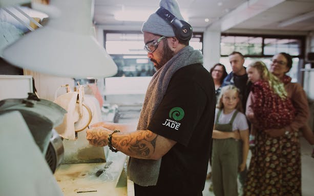 Artisan crafting jade with a group observing during the Mountain Jade Highlights Tour.