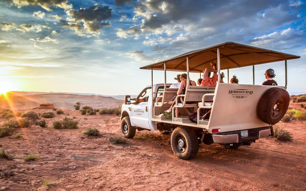 Tour group in open-air vehicle exploring Secret Antelope Canyon and Horseshoe Bend at sunset.