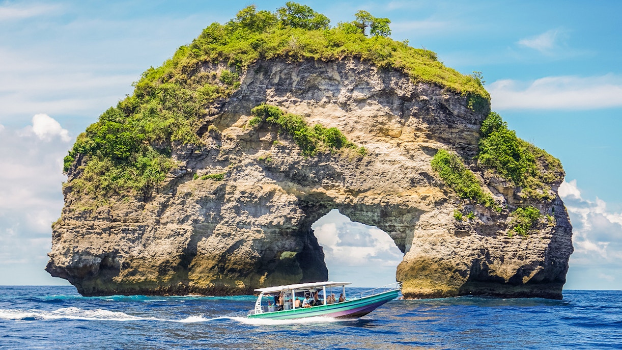 Tourists enjoying a speedboat ride to Nusa Penida Island, Bali, offering exclusive access and unique views of the island