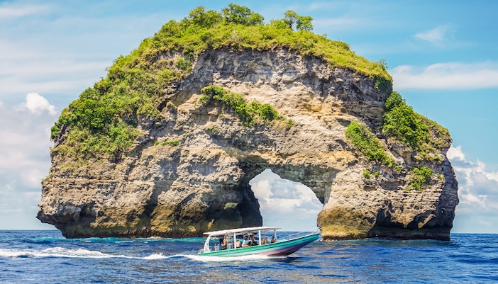 Tourists on a speedboat to Nusa Penida Island, Bali, with exclusive island views.