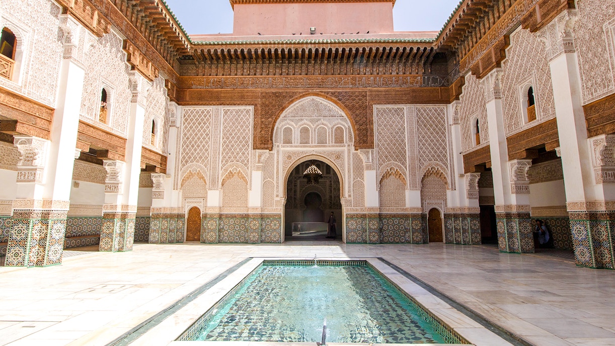 Ben Youssef Madrasa courtyard with intricate tilework and central reflecting pool in Marrakech.