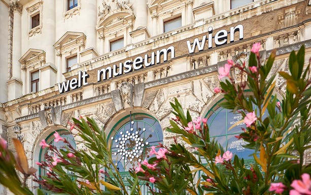 Weltmuseum Wien entrance with decorative facade and flowers in Vienna.