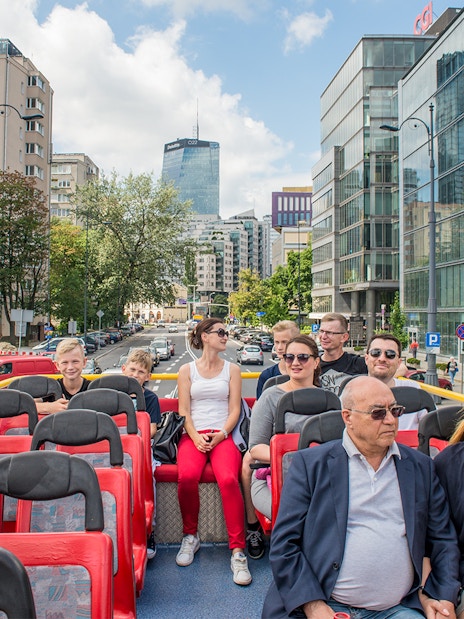 Passengers on an open-top bus tour in Warsaw city center, Poland.