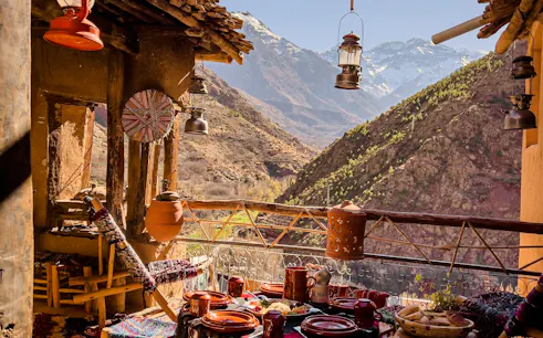 Terrace view of Atlas Mountains with traditional Moroccan meal setup, Marrakesh day trip.