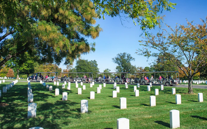 Tram tour passing through Arlington National Cemetery with rows of white headstones.