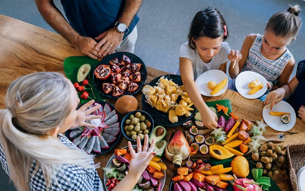 Visitors sampling exotic fruits at Tropical Fruit World farm tour.