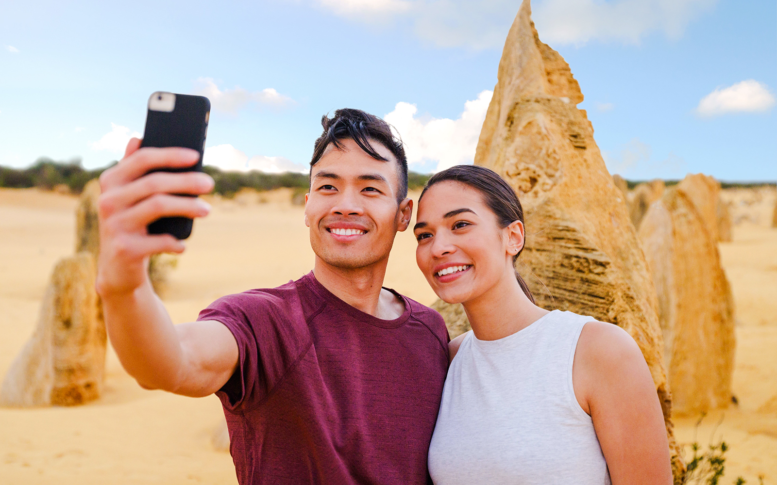 Tourists taking a selfie at Pinnacles Desert during sunset tour.