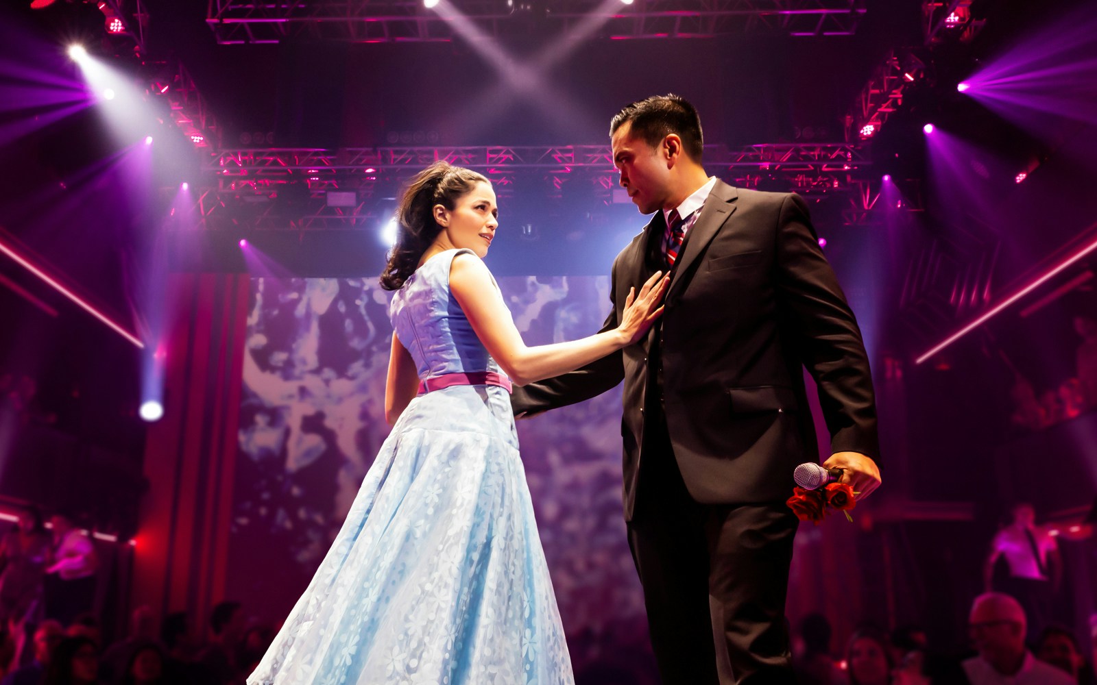 Couple performing on stage during "Here Lies Love" musical.