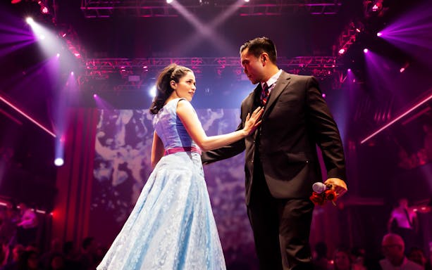 Couple performing on stage during "Here Lies Love" musical.